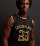 Musculosa deportiva de baloncesto negra con detalles en amarillo, confeccionada en tejido texturizado con tecnología dry fit. Presenta estampado frontal con la inscripción "Los Angeles" y el número 23.