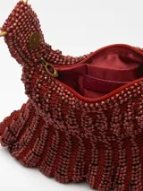 Bolso de mano tipo clutch, color verde, con abalorios tejidos en tricot. Tiene un compartimento con cierre de cremallera y cierre magnético. El asa de mano es metálica con el logo grabado.