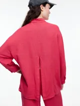 Camisa celeste de calce relajado con abertura en la espalda y mangas largas. Confeccionada en tejido liviano de lino y viscosa. Incluye tres pins decorativos.