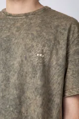 Remera gris con efecto gastado, corte semi-oversize y estampado pequeño en el pecho con un diseño de un girasol.