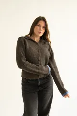 Cárdigan marrón de tejido con relieve, cuello camisero, botones al frente y detalles de color celeste en cuello y puños.