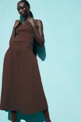 Falda midi marrón con textura, de tiro alto y cierre lateral con cremallera oculta.