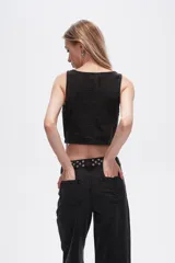 Chaleco crop top de jean celeste con botones frontales.