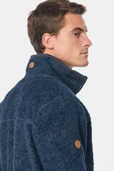 Campera de abrigo azul de corderito con interior de polar y cierre frontal. Presenta un bolsillo de tela lisa en el pecho y bolsillos laterales con cierre.