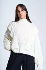Sweater blanco de punto con cuello alto, diseño de ochos y volados en los hombros.