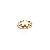 Anillo de acero dorado con detalles en relieve y piedras en la parte superior.