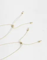 Set de dos pulseras flexibles doradas con dije de corazón y arandela de metal.