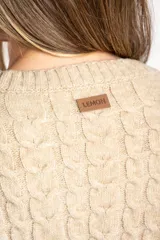 Sweater de punto color beige melange, con cuello redondo y tejido trenzado en el cuerpo y mangas. Presenta un borde inferior de punto acanalado.