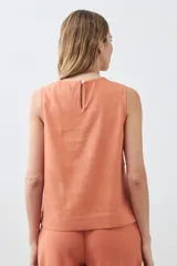 Blusa sin mangas color durazno, confeccionada en lino con efecto desflecado.