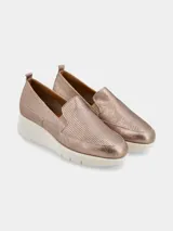 Zapatilla slip on de mujer color oro rosado metalizado, con puntera perforada y suela plataforma blanca gruesa.