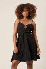 Vestido corto color verde claro, con tirantes finos, detalle de lazo en el escote y falda con volantes escalonados.