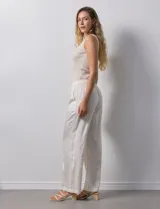 Pantalón palazzo color crudo, marca Nanette, con pretina elastizada, lazo de ajuste y bolsillos delanteros.