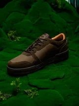 Zapatillas urbanas de cuero color verde oliva con detalles en marrón y negro. Presentan el logo de Star Wars en el talón y el rostro de Yoda grabado en el lateral.