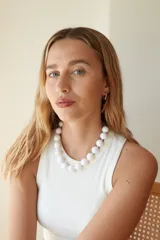 Collar de cuentas esféricas grandes de acrílico blanco, ensartadas en un cordón claro.