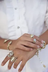 Brazalete rígido dorado con forma de caracola en los extremos.