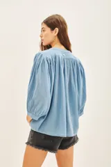 Camisa amarilla de algodón con corte amplio, cuello redondo y mangas 3/4 con puños elásticos.