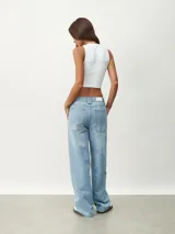 Pantalón de jean celeste, de corte ancho y tiro alto, con bolsillos laterales y traseros.
