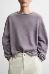 Jersey de hombre color lila, tejido en hilatura de algodón con textura. Tiene cuello redondo, manga larga y acabados en rib con detalle de vuelta.