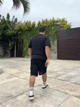 Conjunto negro tejido calado, compuesto por una remera de corte cuadrado y shorts.