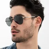 Lentes de sol INVU estilo aviador, con montura dorada y negra, y lentes verdes polarizadas.