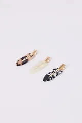 Set de tres hebillas para el pelo con diseño de carey en tonos marrón, blanco y negro. Cuentan con un broche metálico dorado.