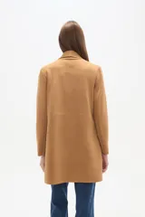 Tapado largo color camel, de manga larga y corte holgado, con solapa tipo chal y bolsillos frontales.