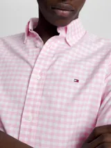 Camisa de algodón Oxford con motivo de cuadros Vichy rosas y blancos, corte regular, cuello con botones, puños con botones y logo de Tommy Hilfiger bordado en el pecho.