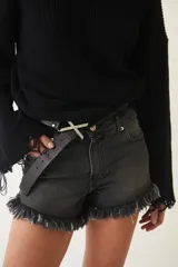 Short de jean negro con tiro bajo, efecto desgastado y flecos en el ruedo.