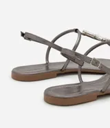 Sandalia plana dorada con tiras finas y aplicación de pedrería.