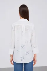 Camisa blanca de algodón con bordado tipo broderie, corte holgado, cuello camisero y mangas 3/4.