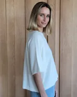 Buzo de punto color verde kiwi con cuello, puños y ruedo en azul.