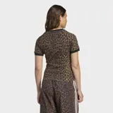 Remera Adidas de corte slim fit con cuello redondo y mangas cortas. Diseño con estampado de leopardo y las tres tiras clásicas de Adidas en color blanco sobre los hombros.