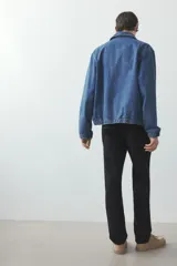 Pantalón de vestir negro con pliegues, corte recto y bolsillos laterales.