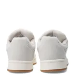 Zapatillas deportivas negras con detalles en blanco, suela blanca y base marrón.