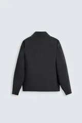 Sobrecamisa negra de corte amplio, con cuello solapa, manga larga con puños abotonados, bolsillos de parche en el pecho, bolsillos laterales y cierre frontal con botones.