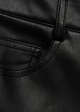 Pantalón largo de tiro alto color negro, con efecto piel, diseño recto, cinco bolsillos, trabillas y cierre de cremallera y botón.
