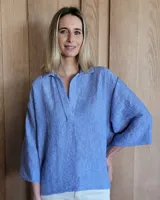 Blusón celeste de corte holgado, con cuello polo y mangas 3/4.