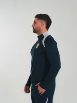 Remera de entrenamiento Nike color azul marino con detalles en gris en los hombros y logo de la selección uruguaya en el pecho.