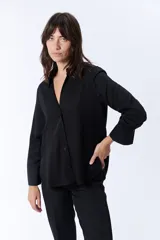 Camisa negra de manga larga con cuello clásico y cierre frontal con botones.