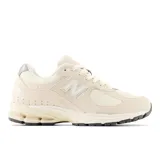 Championes New Balance 2002R color crema, con detalles en blanco y gris. Capellada de gamuza y malla, entresuela ABZORB y suela N-ergy.