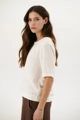 Blusa color crudo de lino con cuello redondo y mangas cortas.
