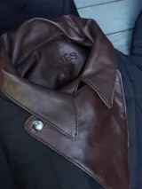 Campera puffer azul marino con diseño acolchado de rombos, cuello de cuero sintético negro, mangas largas abullonadas con puños elásticos y cierre frontal con cremallera.