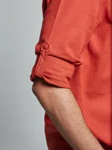 Camisa blanca de lino con cuello mao y mangas largas con presilla para enrollar.