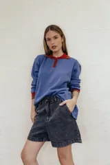 Buzo azul de algodón con cuello polo rojo con botones y puños acanalados.