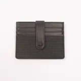 Tarjetero negro con textura tejida en la parte inferior y cierre con broche a presión.
