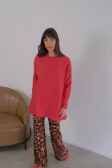 Buzo azul de viscosa con cuello redondo y manga larga. Presenta un aplique con diseño geométrico en el brazo izquierdo.