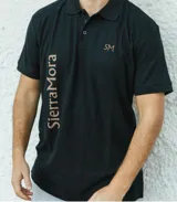 Remera tipo polo azul con cuello clásico, mangas cortas y bordado de las iniciales SM en color beige.