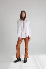 Pantalón de vestir color cobre con acabado brillante, corte recto y aberturas en el ruedo.