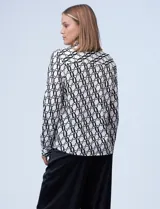 Camisa estampada de rayón con cuello con solapa y abertura central con botones ocultos, color blanco con diseño negro.