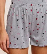 Conjunto de pijama short doll confeccionado en rib, compuesto por una musculosa con puño y un short con cintura elástica, ambos con estampado de corazones.